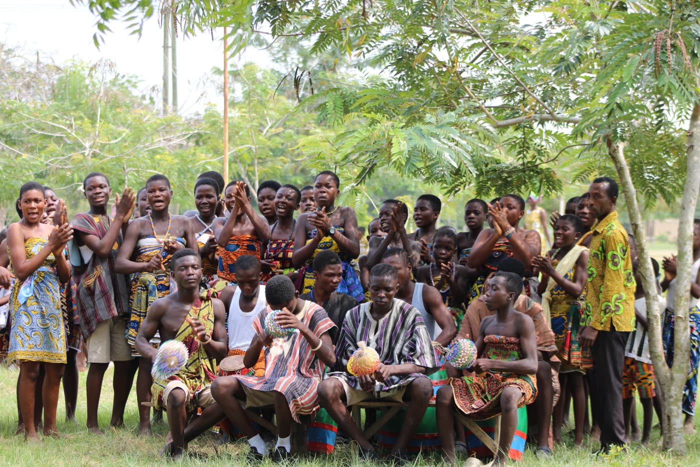 Community members in traditional dress dancing at a celebration in the Volta Region