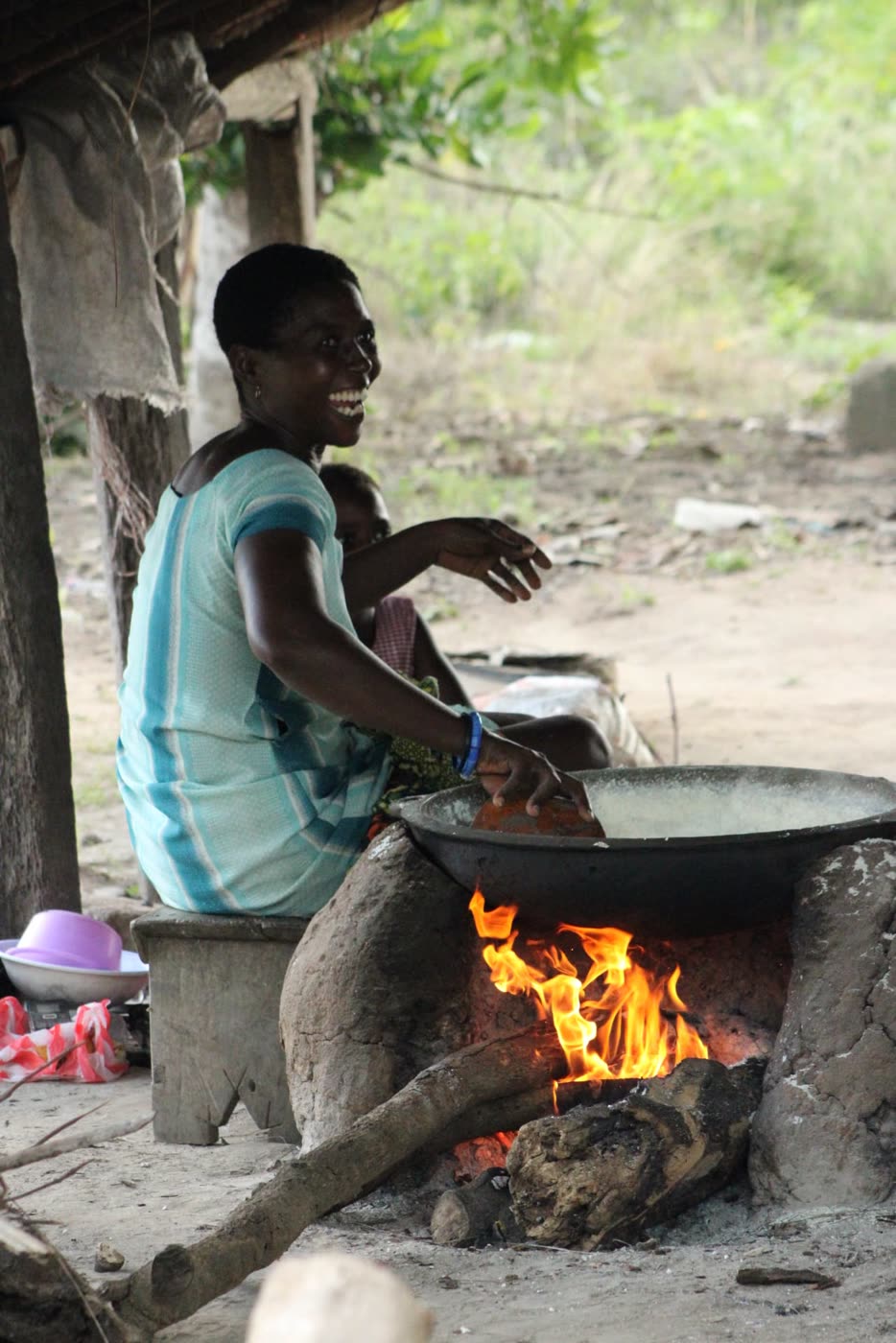 A woman cooking over an open fire
