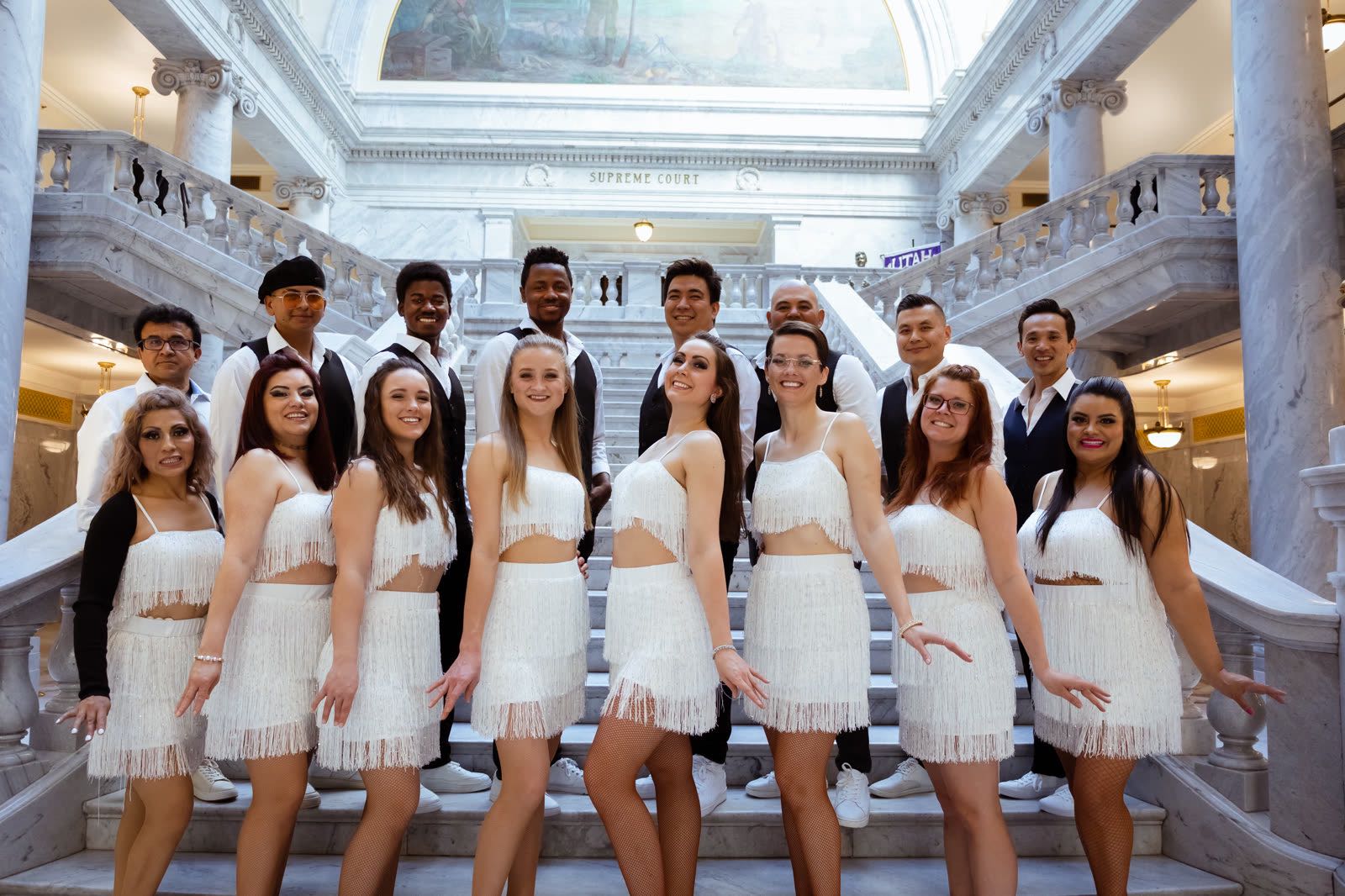 The Bachata Angels in white outfits on a staircase