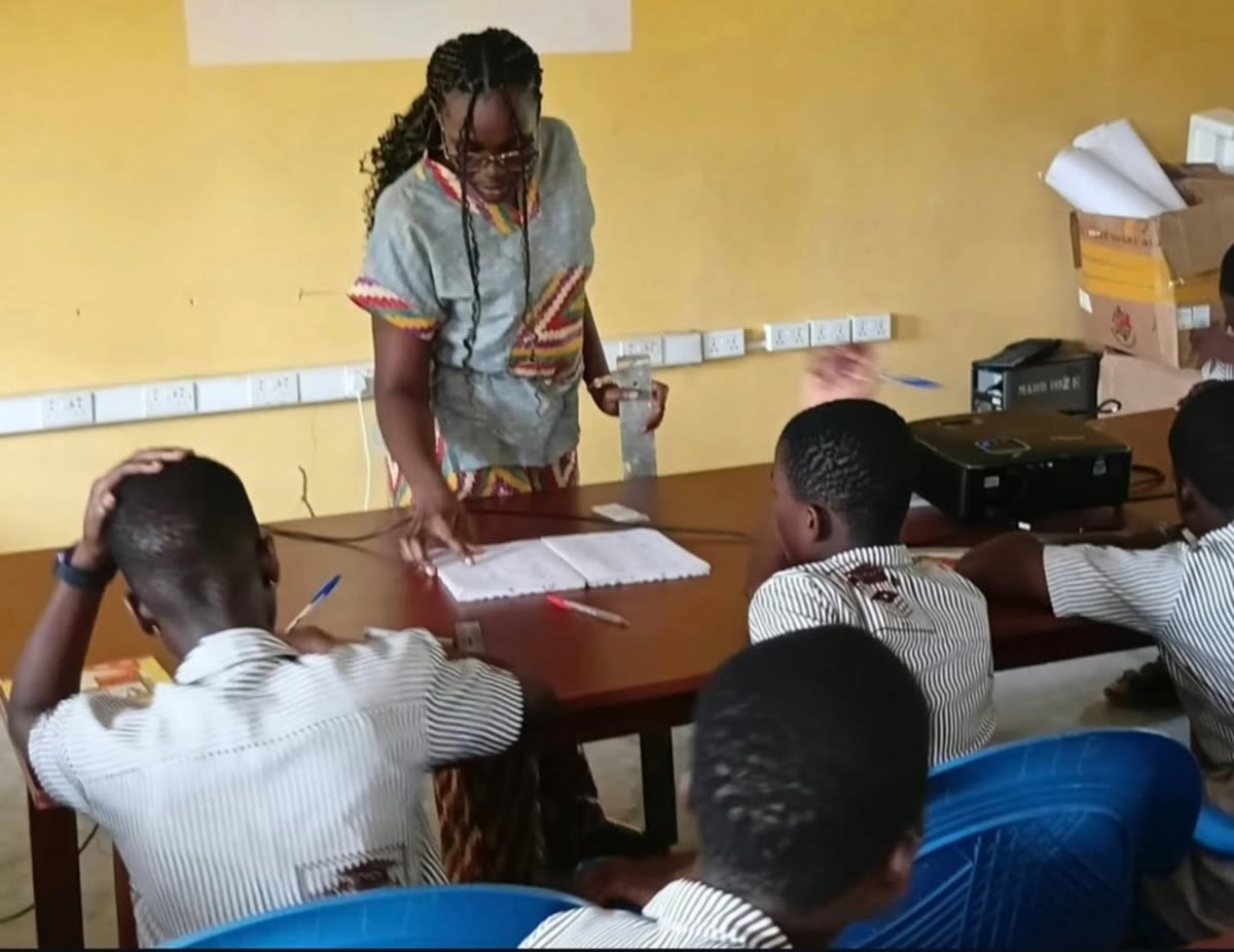 A teacher checks a student's work during a math lesson in the lab