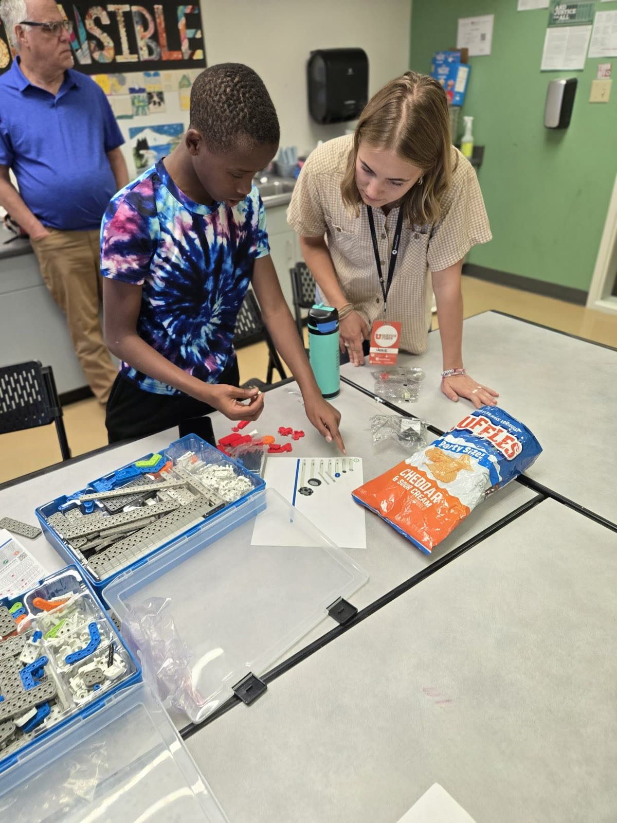 A young mentor guides a student as he builds a VEX robot in our Utah Robotics & AI class