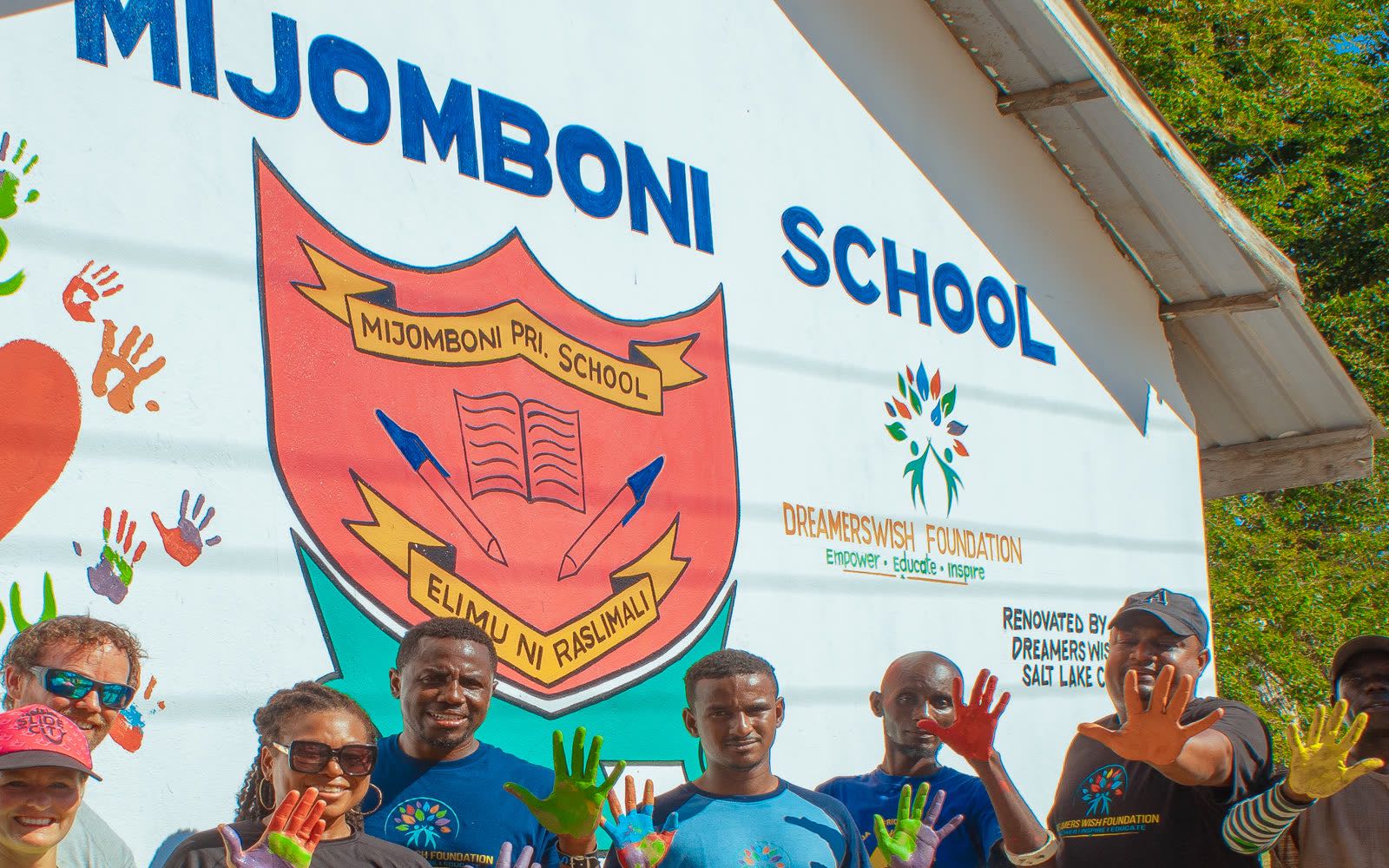 After: the Mijomboni School wall with colorful handprints and a heart