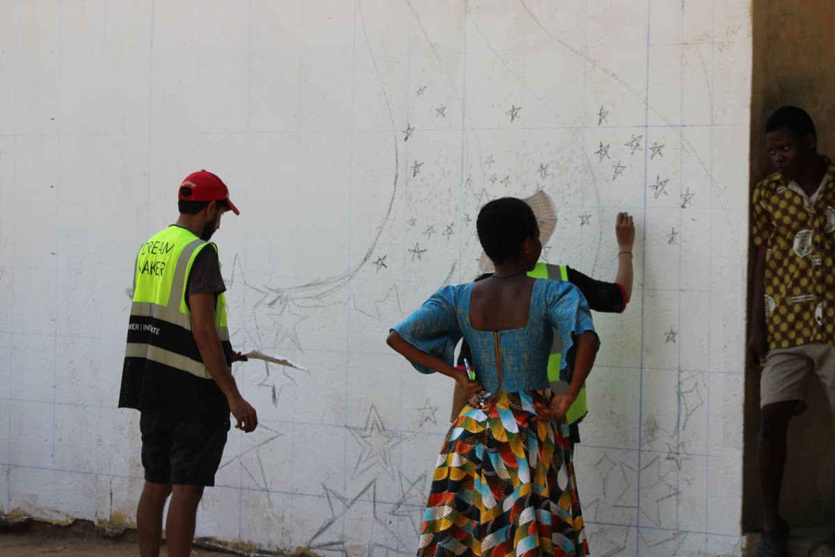 Volunteers priming a wall from ladders