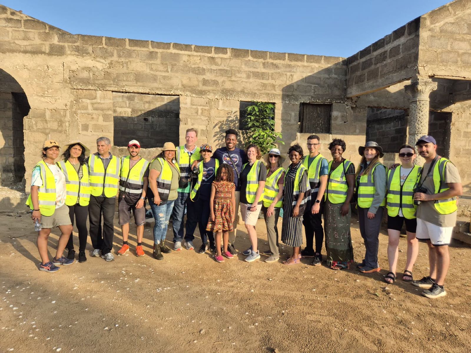 A team of Dreamers Wish volunteers in safety vests together in Ghana